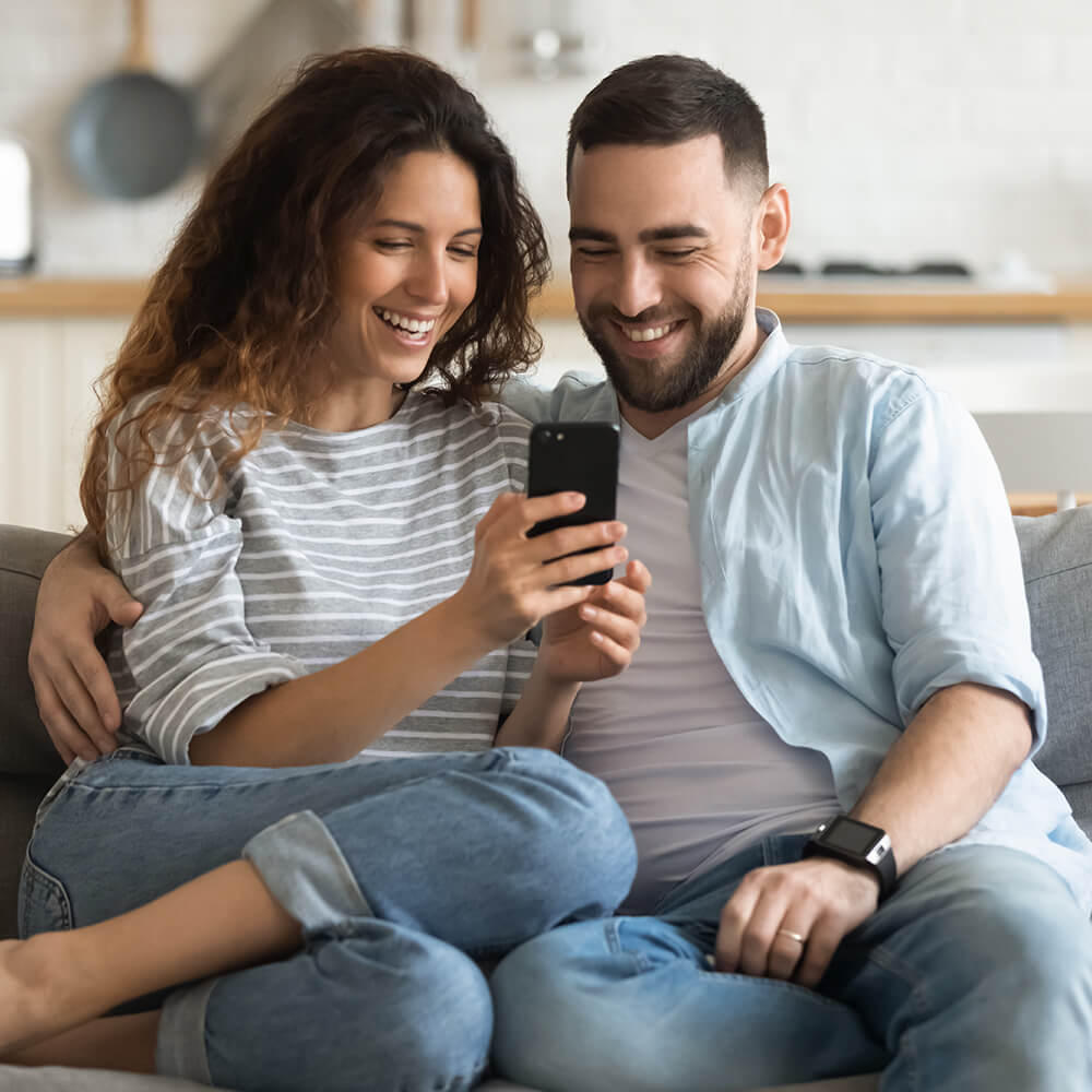 couple on phone on sofa
