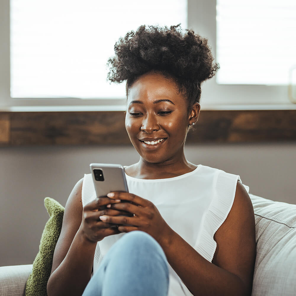 woman sitting on the sofa on her phone