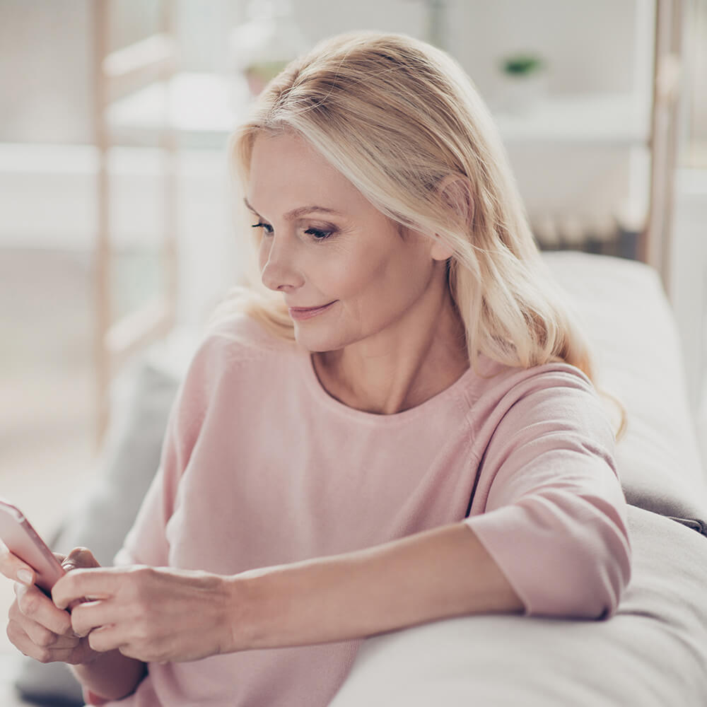 woman on phone sitting on sofa