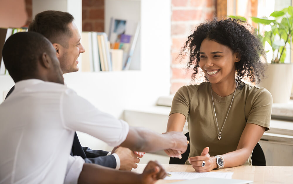 woman shaking hands after being accepted for a loan