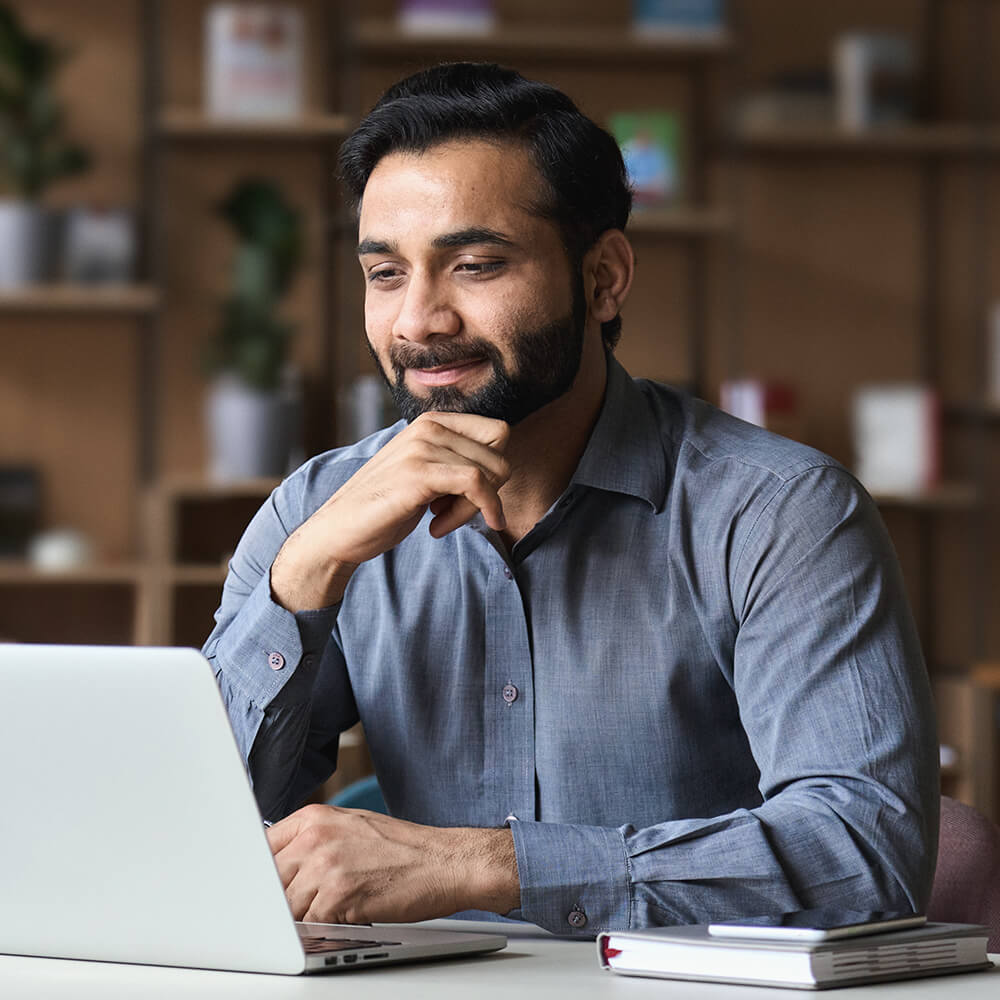 man smiling at his laptop