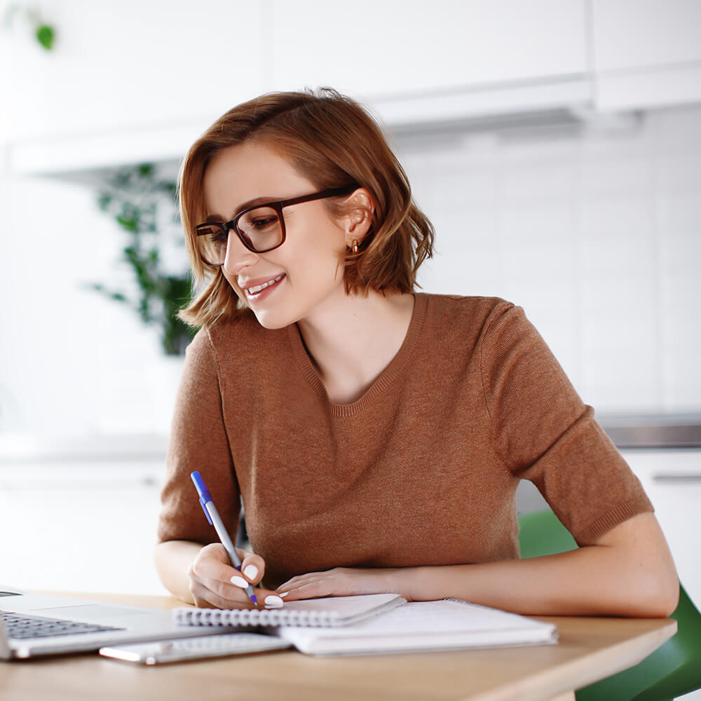 woman writing notes on notepad