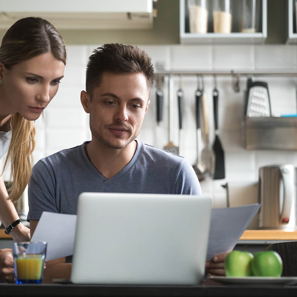 couple read over document in kitchen