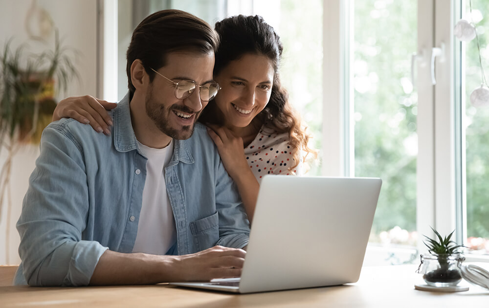 couple smiling over laptop