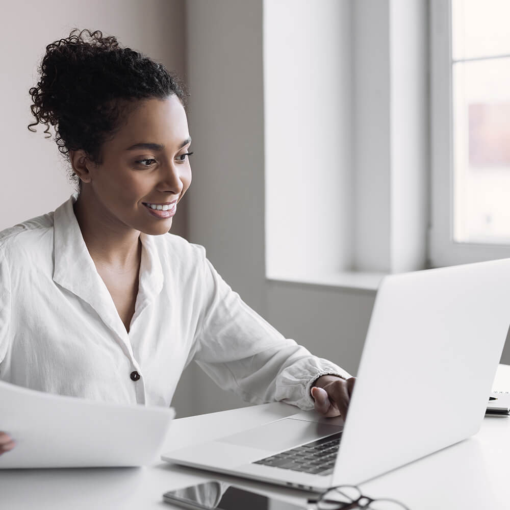women smiling while reading over papers