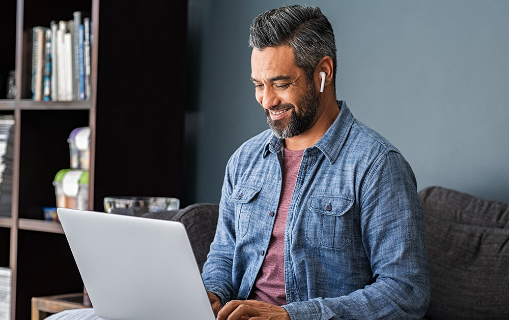 Man smiling at his laptop