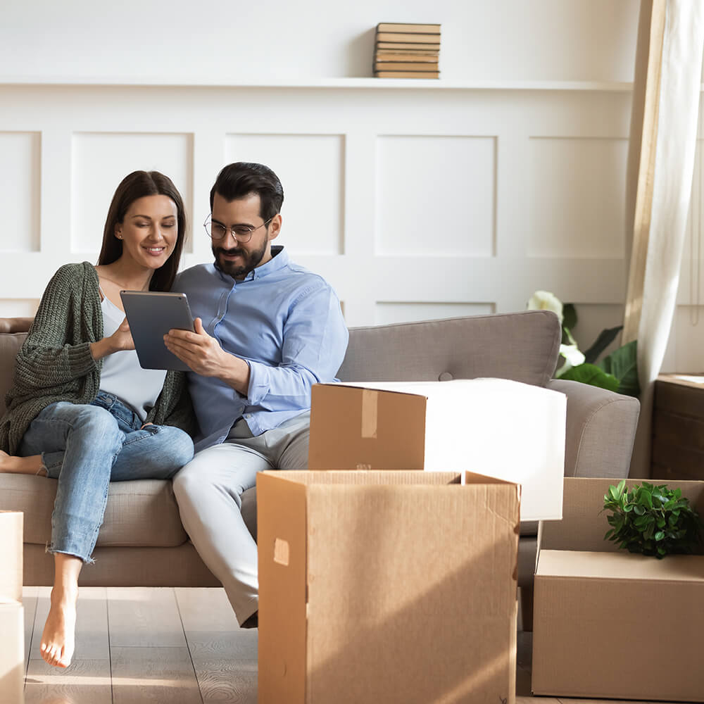couple smiling at iPad in a room
