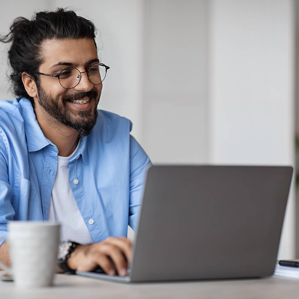 man smiling at laptop