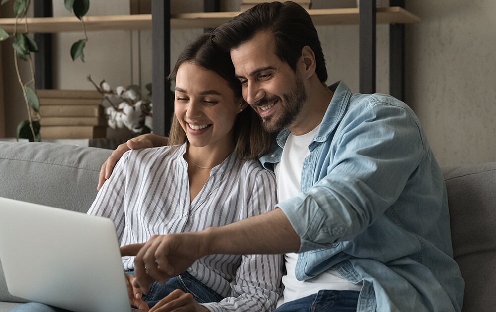 couple smiling at laptop