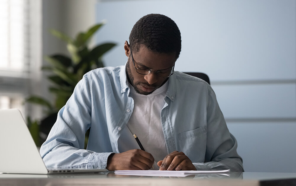 man writing on paper