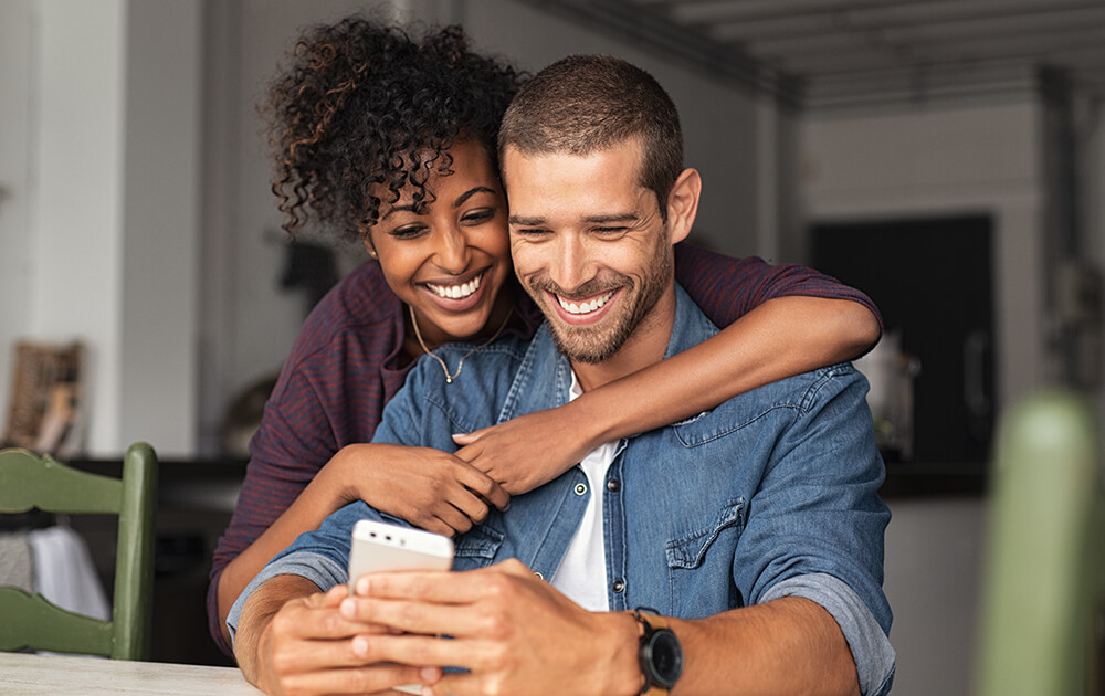 couple smiling over a phone