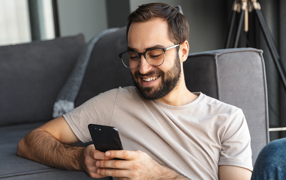 man smiling at phone