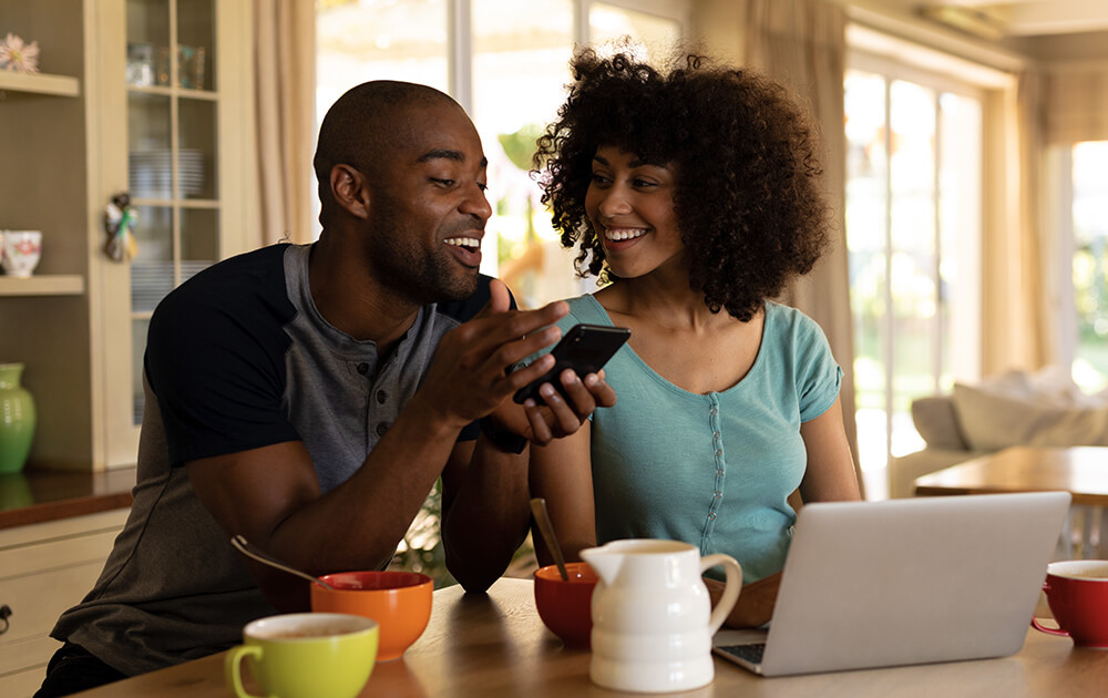 couple smiling at laptop