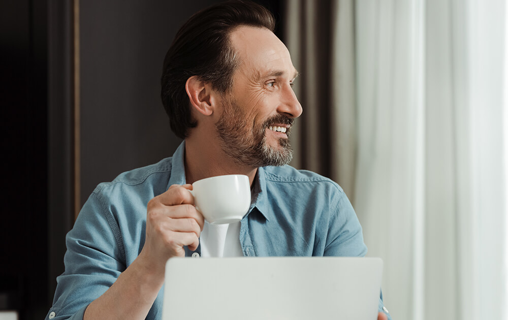 man smiling at laptop